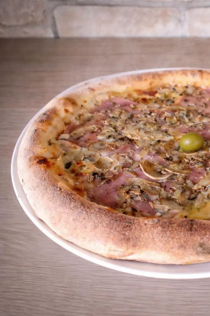 Pizza Capricciosa: umak od rajčice, sir, šunka, gljive, masline, origano