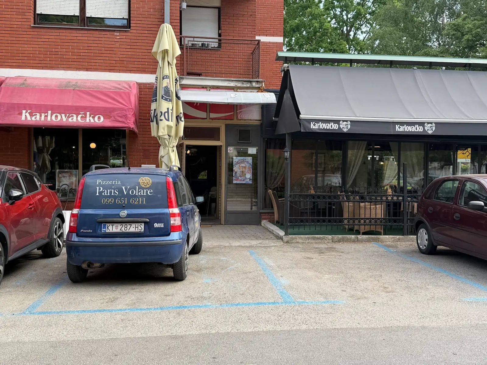 Ulaz u pizzeriju Paris Volare u Ulici Andrije Hebranga u Kutini, s terasom i dostavnim vozilom